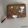 Coach Kleine Geldbörse mit Rundum-Reißverschluss aus charakteristischem Canvas mit Peanuts-Snoopy-Woodstock-Print, Kaffee