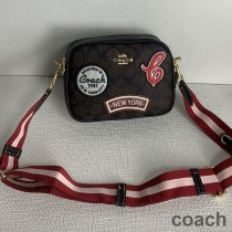Torba fotograficzna Coach Mini Jamie z płótna Signature Canvas z naszywkami narciarskimi w kolorze brązowo-czarnym