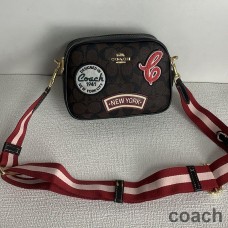 Bolso para cámara Coach Mini Jamie en lona distintiva con parches de esquí en marrón y negro